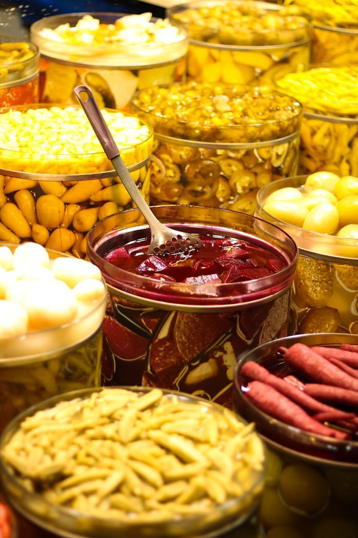 Vibrant display of pickled vegetables in jars at a marketplace in Bursa, Türkiye.