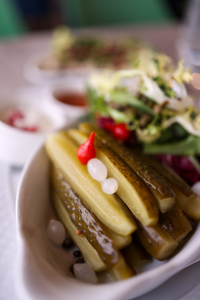 Close-up of fresh pickles and vegetables served with salad for a healthy snack.