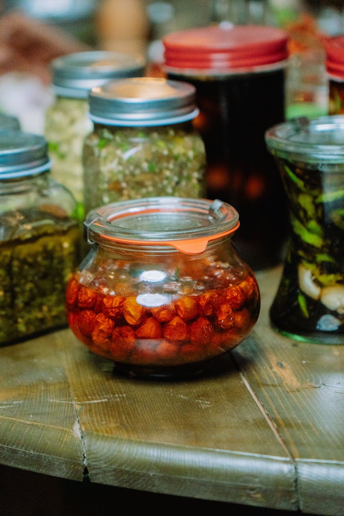 Colorful assorted pickled jars displayed on a rustic wooden table, showcasing vibrant food preservation.