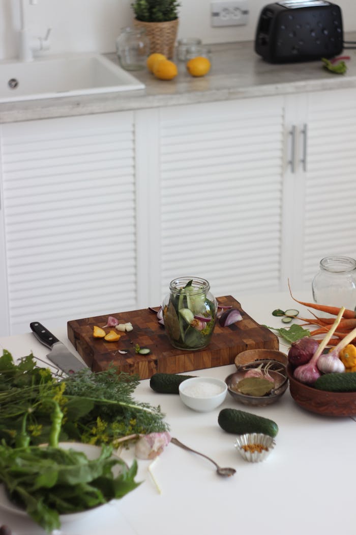 Fresh vegetables and herbs on a kitchen counter for homemade pickling.